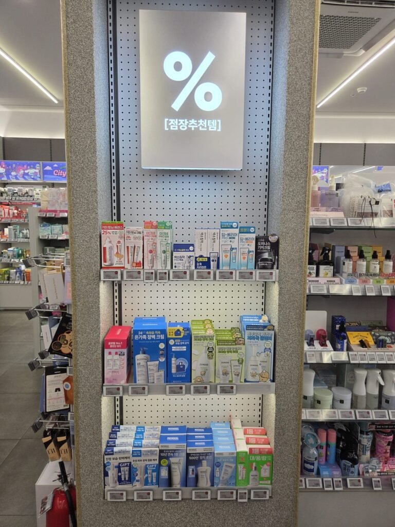 Olive Young end-cap display under a lit sign with a percent symbol and the words 점장추천템, the store manager's picks