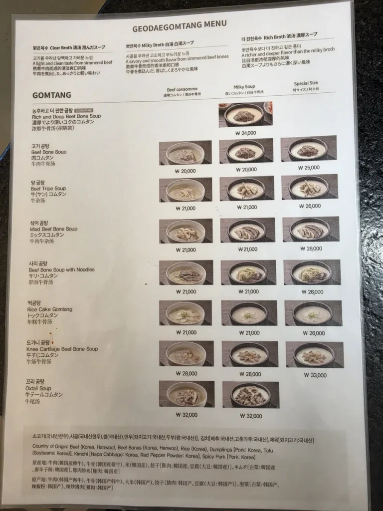 The Geodae Gomtang menu in Korean, English, Chinese and Japanese: three broths at the top, then eight kinds of gomtang with prices for clear broth, milky broth and special size, and the country-of-origin notice for Korean Hanwoo beef
